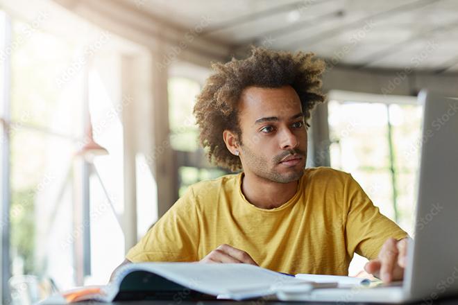 man studying and typing on laptop